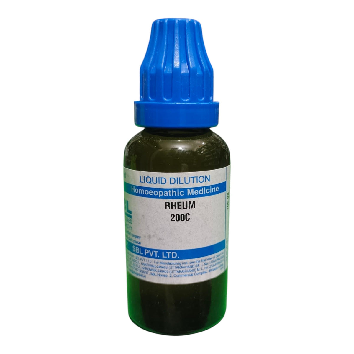 A dark glass bottle of Rheum liquid dilution homeopathic medicine with a blue cap, on a white background.