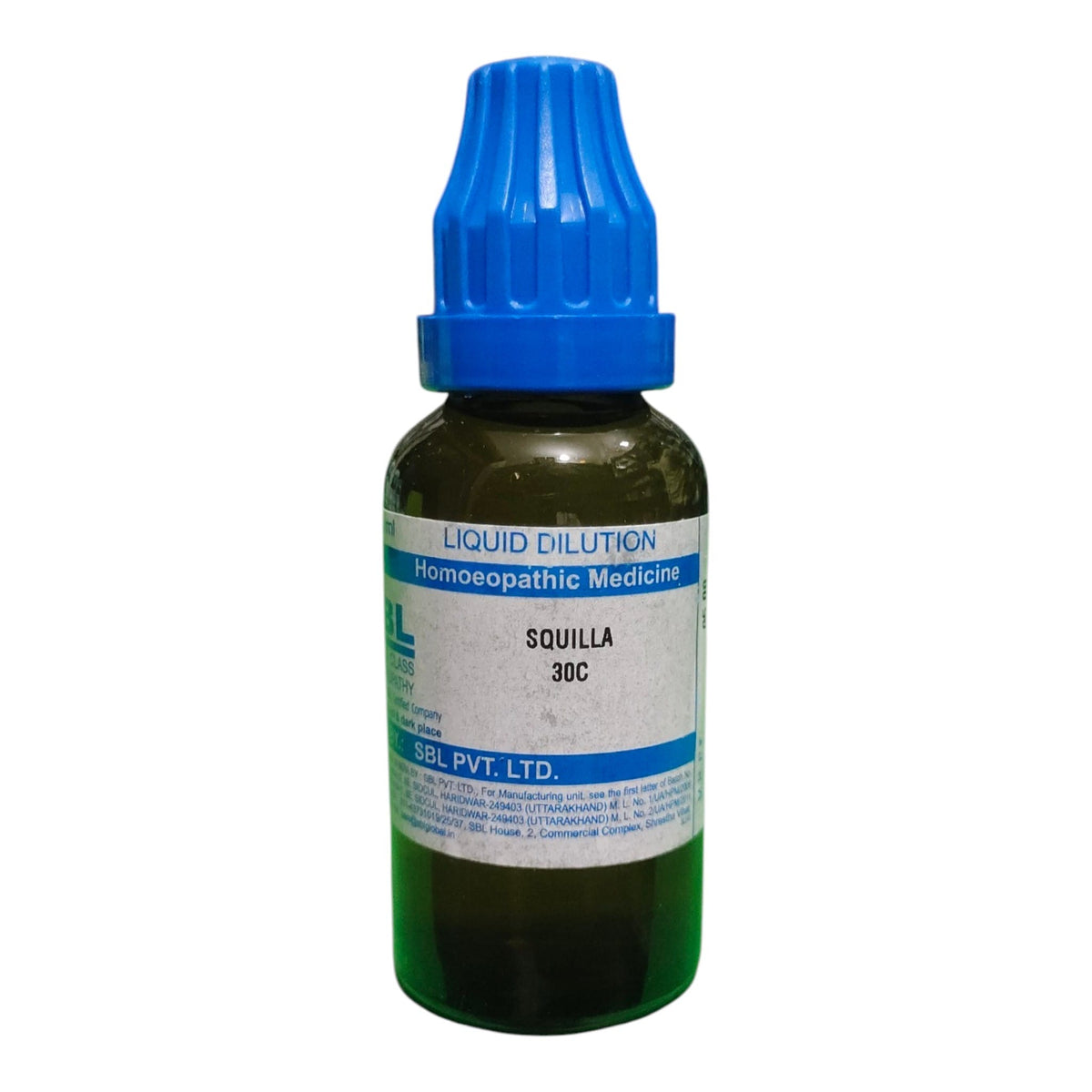 A small bottle of homeopathic liquid dilution medicine labeled 'Squilla 30C' by SGL PVT. LTD.