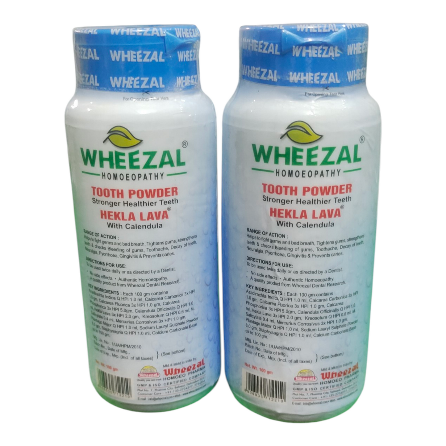 Two bottles of Wheezal tooth powder on a white background