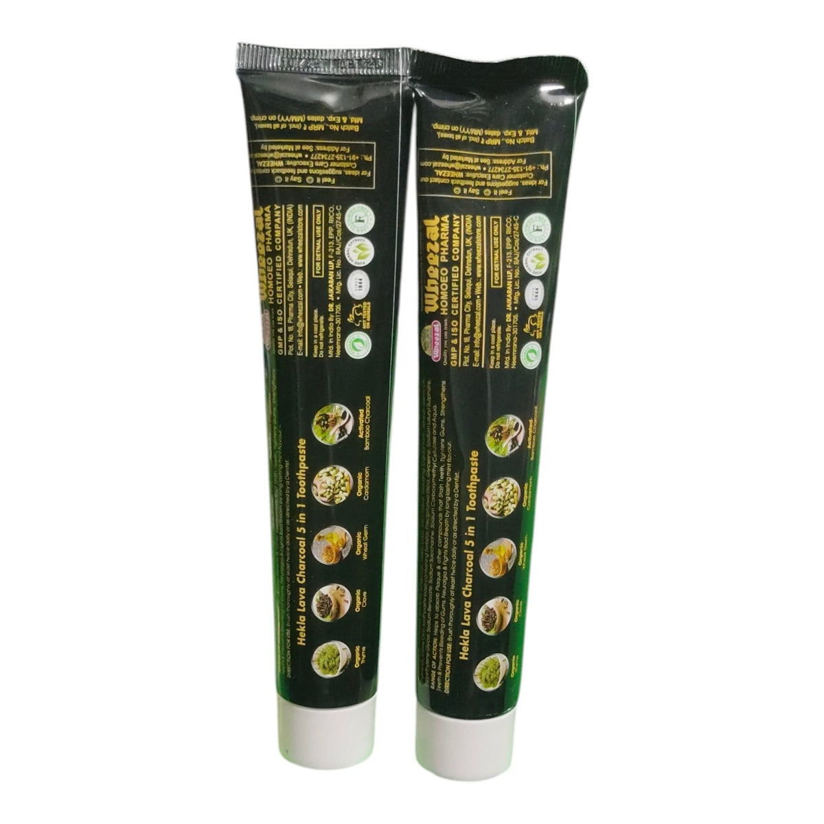 Two black squeeze tubes of toothpaste with white caps, showing the back packaging with yellow text and ingredient icons, on a plain white background.
