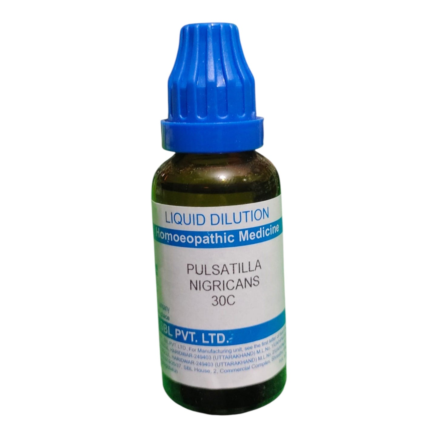 A small amber glass bottle of homeopathic medicine with a blue ribbed cap and a white label reading 'LIQUID DILUTION', 'homeopathic medicine', and 'PULSATILLA NIGRICANS 30C'.
