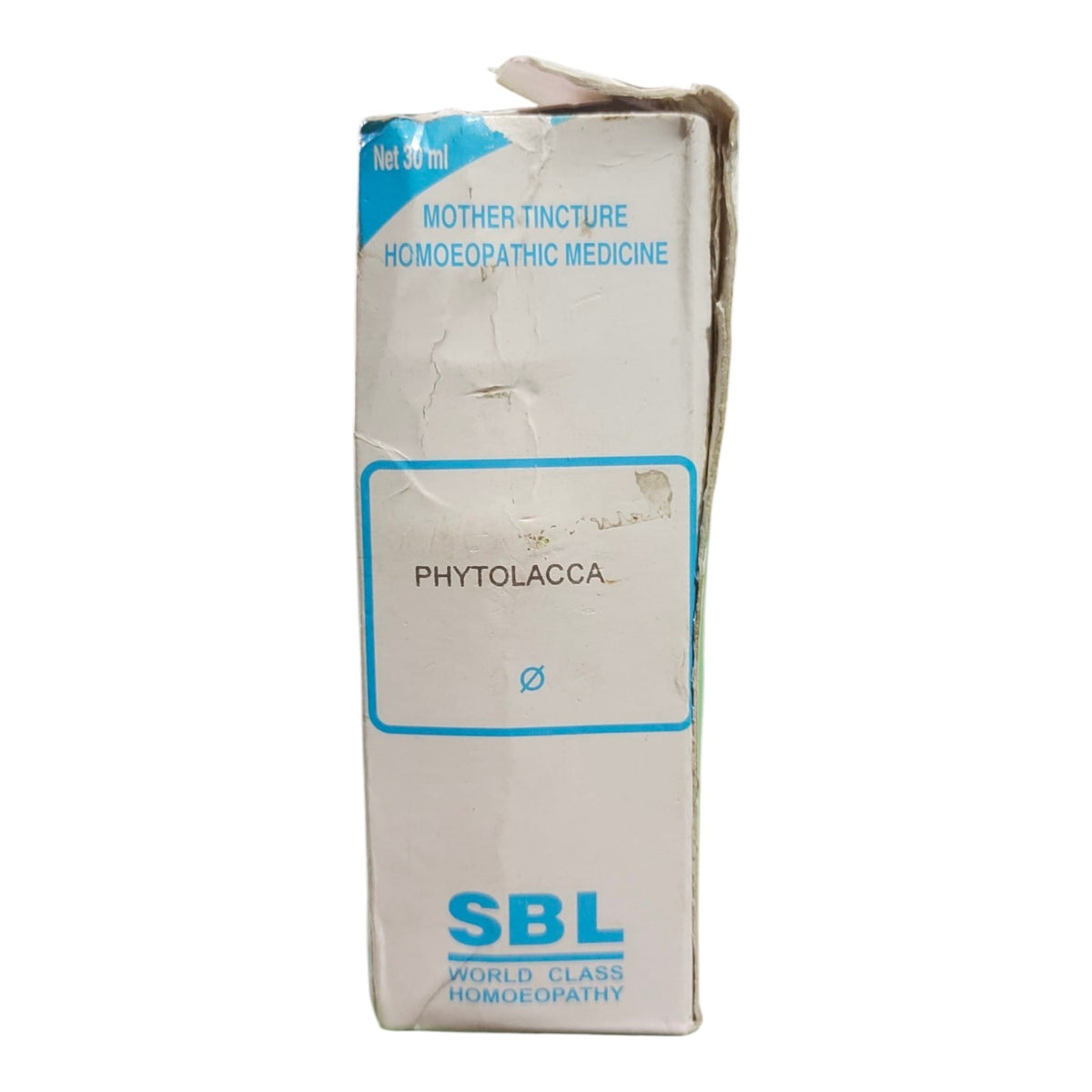 A worn cardboard box of SBL World Class Homoeopathy Mother Tincture Phytolacca, featuring blue text and border on a white background.