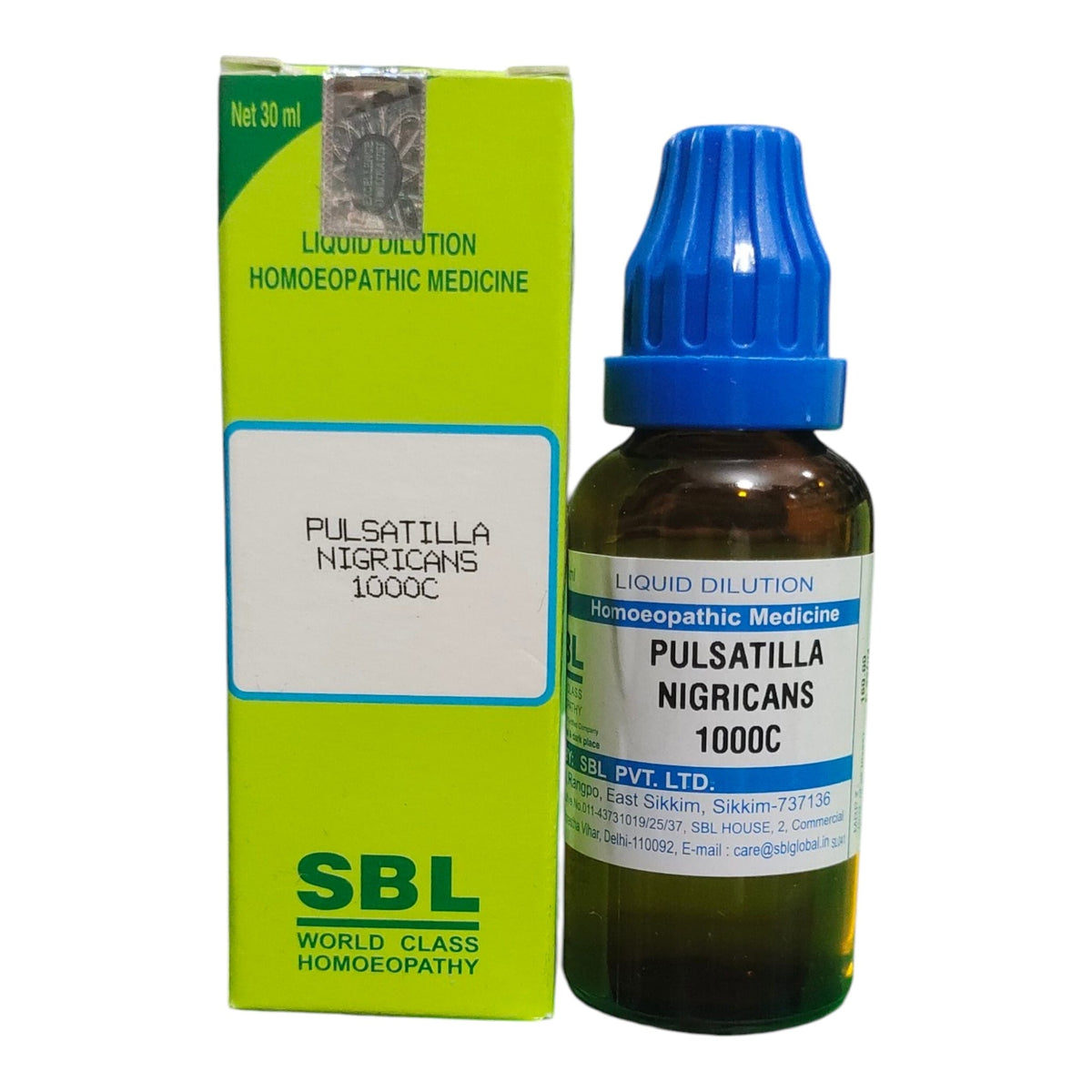 A bottle of Pulsatilla Nigricans 1000C liquid dilution homeopathic medicine next to its lime green and white packaging box, featuring a blue dropper cap.