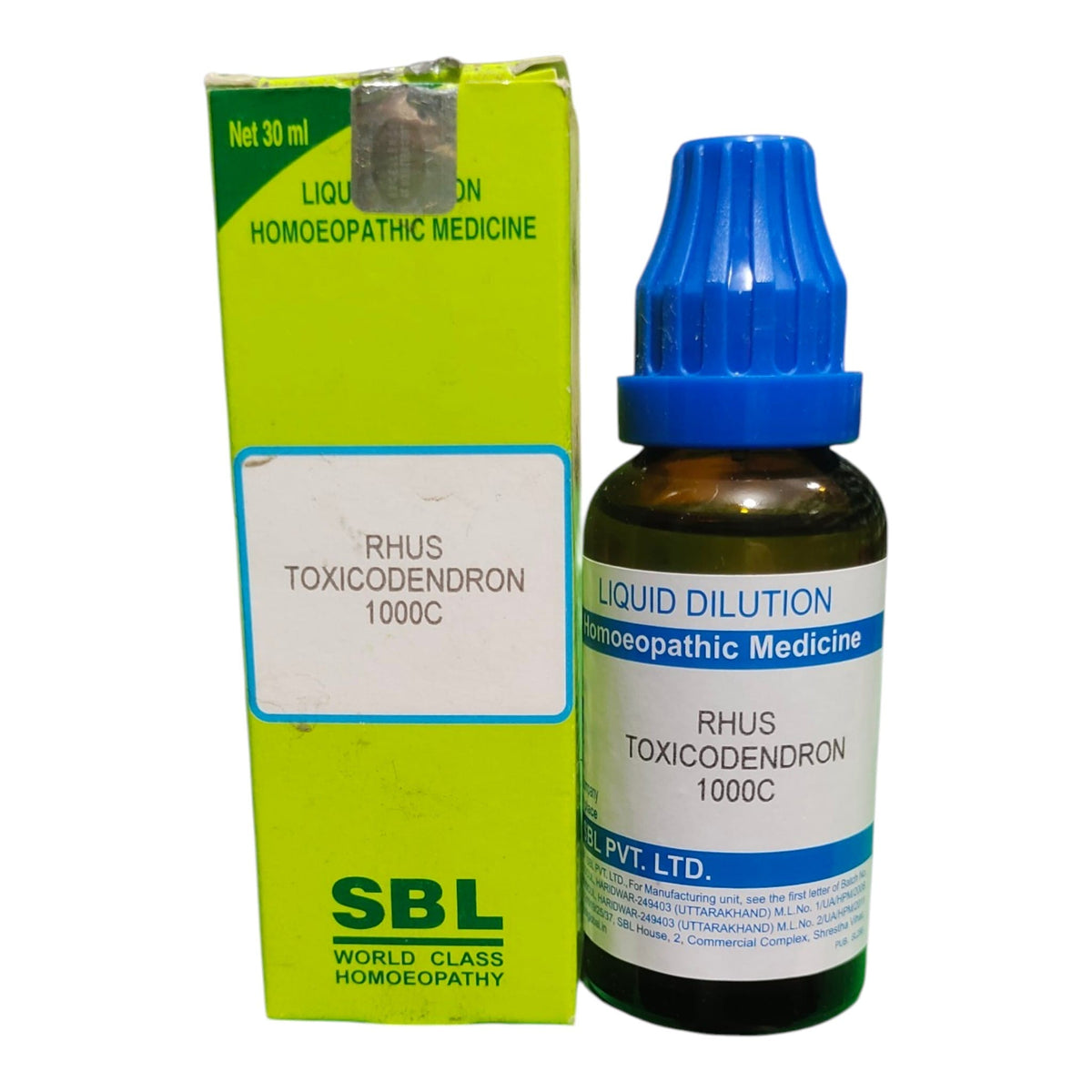 A bottle of SBL Rhus Toxicodendron 1000C homeopathic medicine next to its lime green box, on a white background.