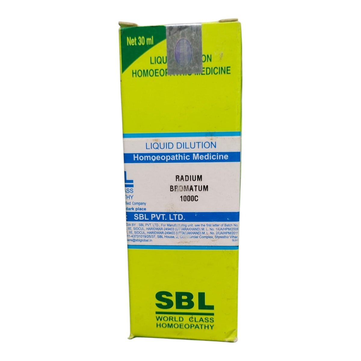 A tall rectangular box of SBL Liquid Dilution Homeopathic Medicine, featuring a bright yellow-green background with blue and white text bands and the SBL logo at the bottom.