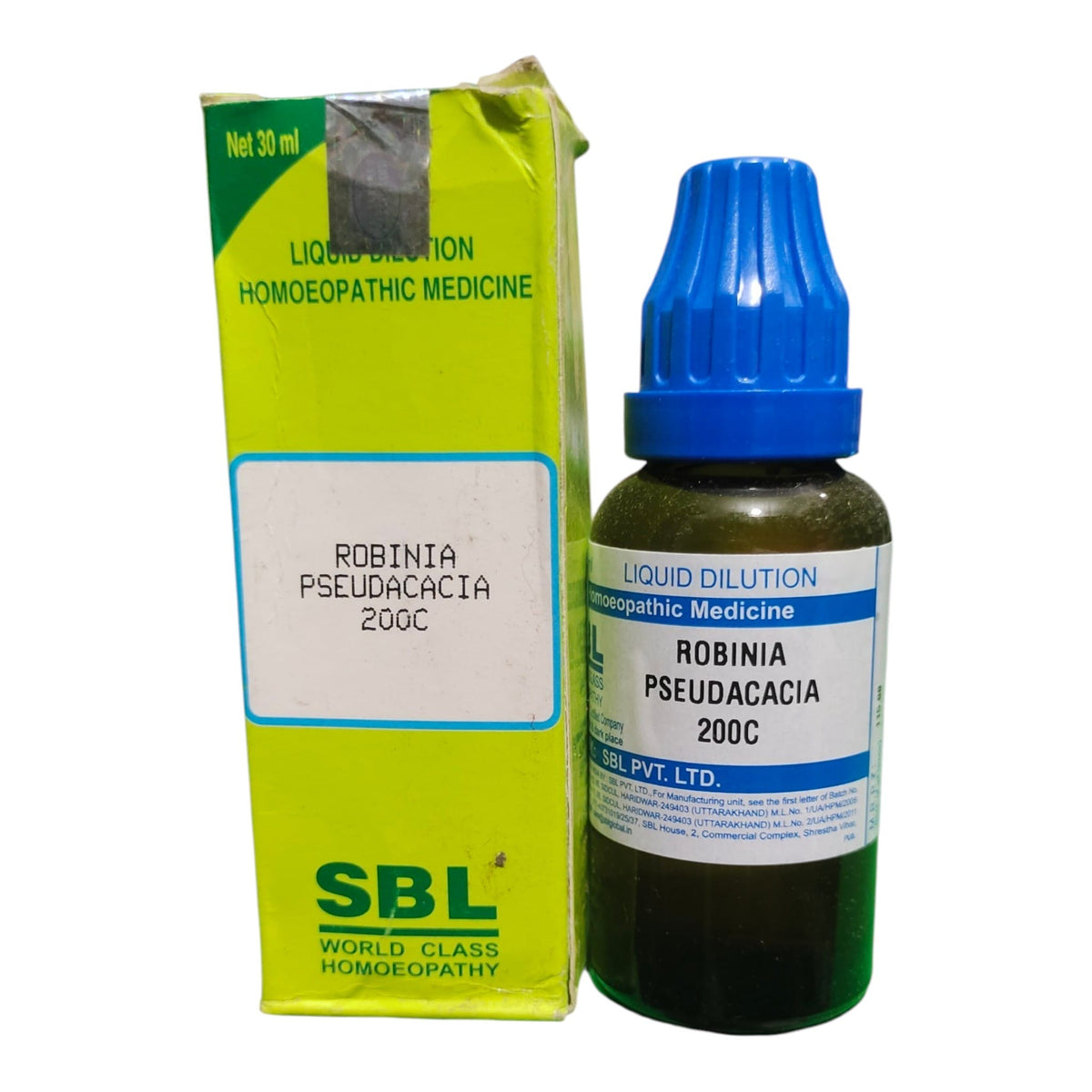 A bottle of SBL Liquid Dilution Homeopathic Medicine (Robinia Pseudacacia 200c) with a blue cap next to its lime green and white cardboard packaging box, set against a plain white background.