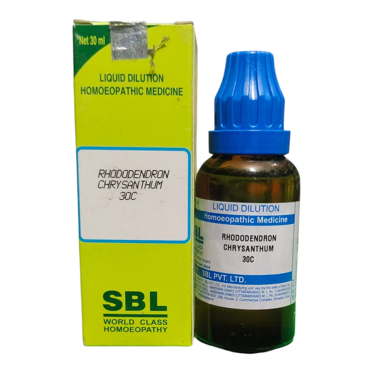 A bottle of SBL Liquid Dilution Homeopathic Medicine next to its lime green box, featuring a blue dropper cap and a white label with blue text.