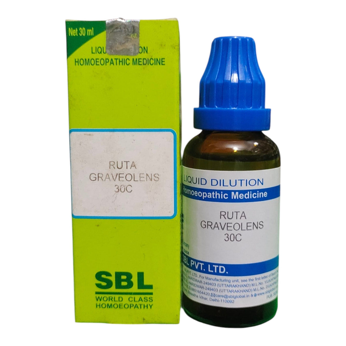 A bottle of SBL Liquid Dilution Ruta Graveolens 30C homeopathic medicine next to its lime green packaging box, on a white background.