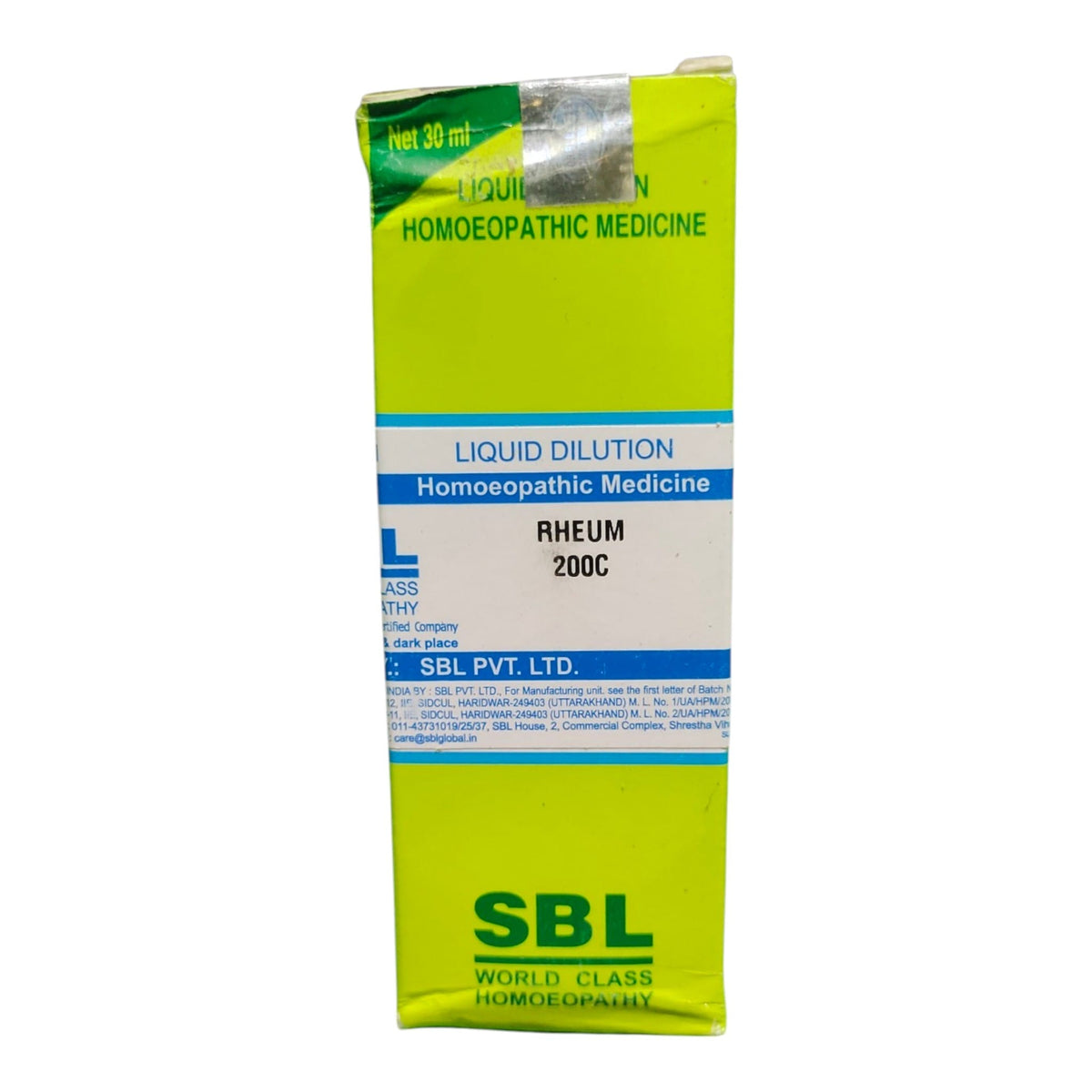 A box of SBL Liquid Dilution Homoeopathic Medicine Rheum 200C, featuring a bright lime green and white design with blue text accents.
