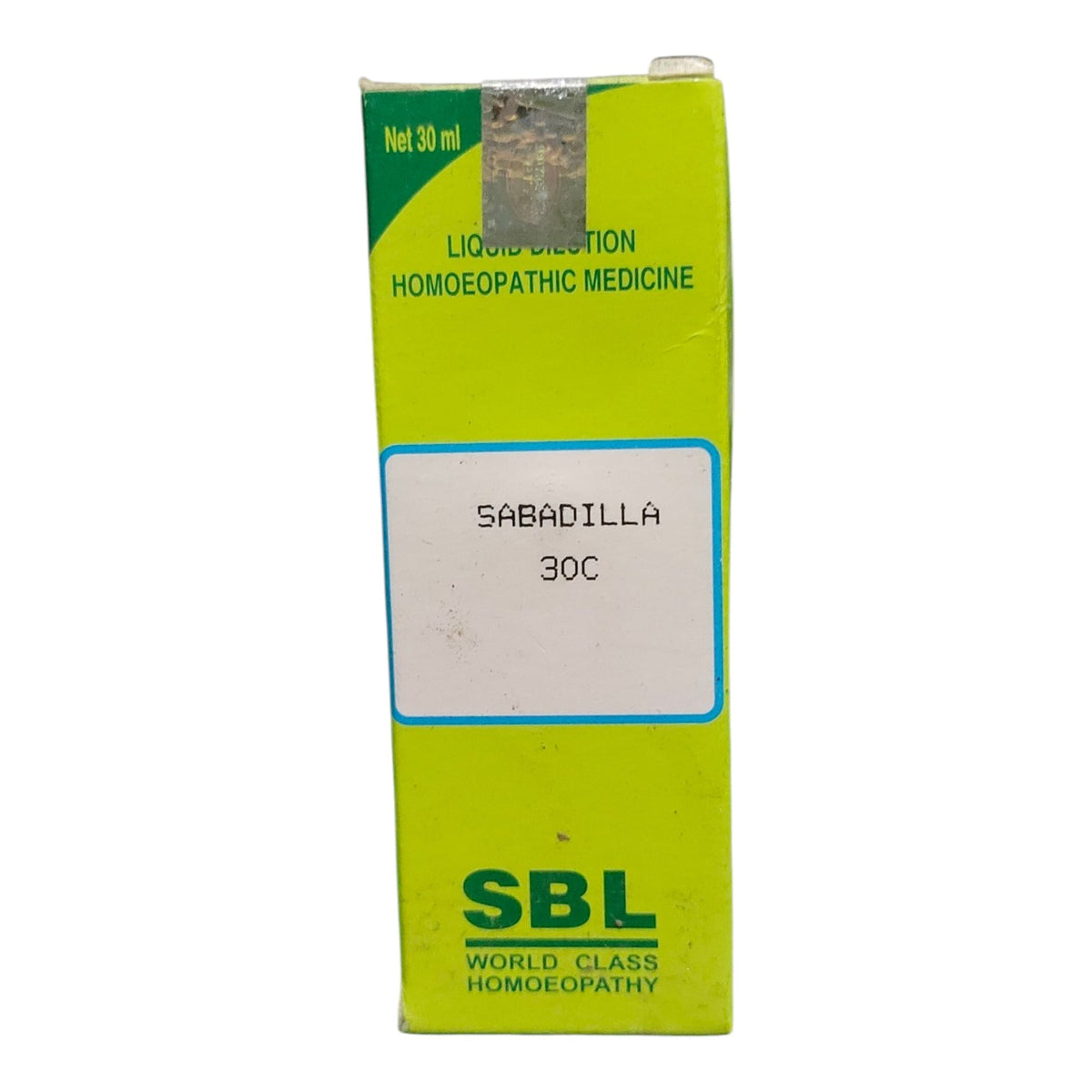 A lime green cardboard box of SBL Sabadilla 30C liquid injection homeopathic medicine, featuring a white label in the center and green text.