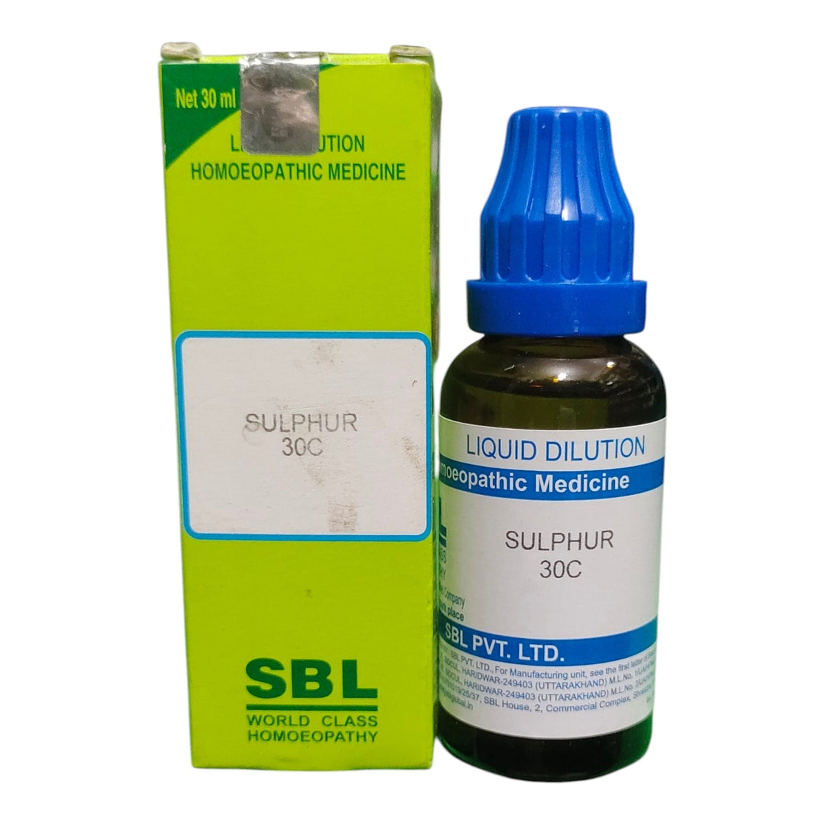 A bottle of SBL Liquid Dilution Sulphur 30C homeopathic medicine next to its lime green box, on a white background.