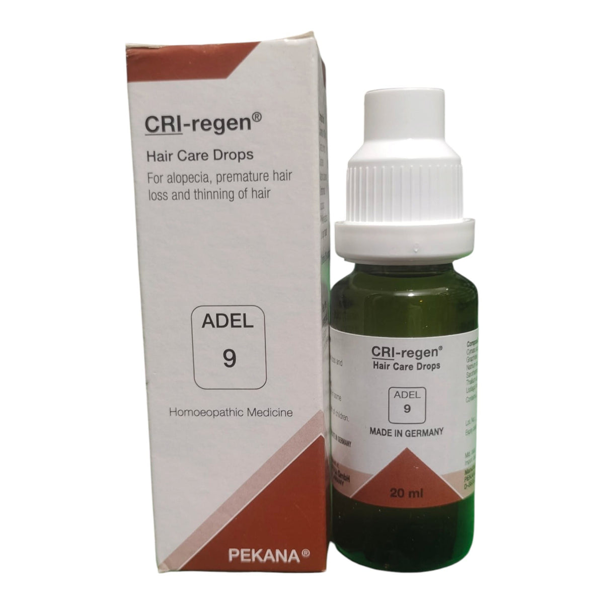A bottle of CRI-regen Hair Care Drops next to its cardboard packaging box, featuring a white cap, dark green glass bottle, and white and brown labels.