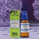 SBL Calcareum Carbonicum homeopathic medicine bottle and packaging on a blurred floral background